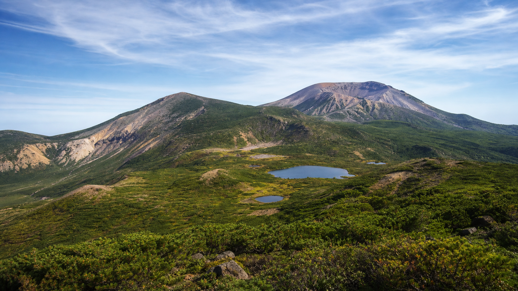 火山群と湿原を含む広い山域を望む吾妻山のイメージ