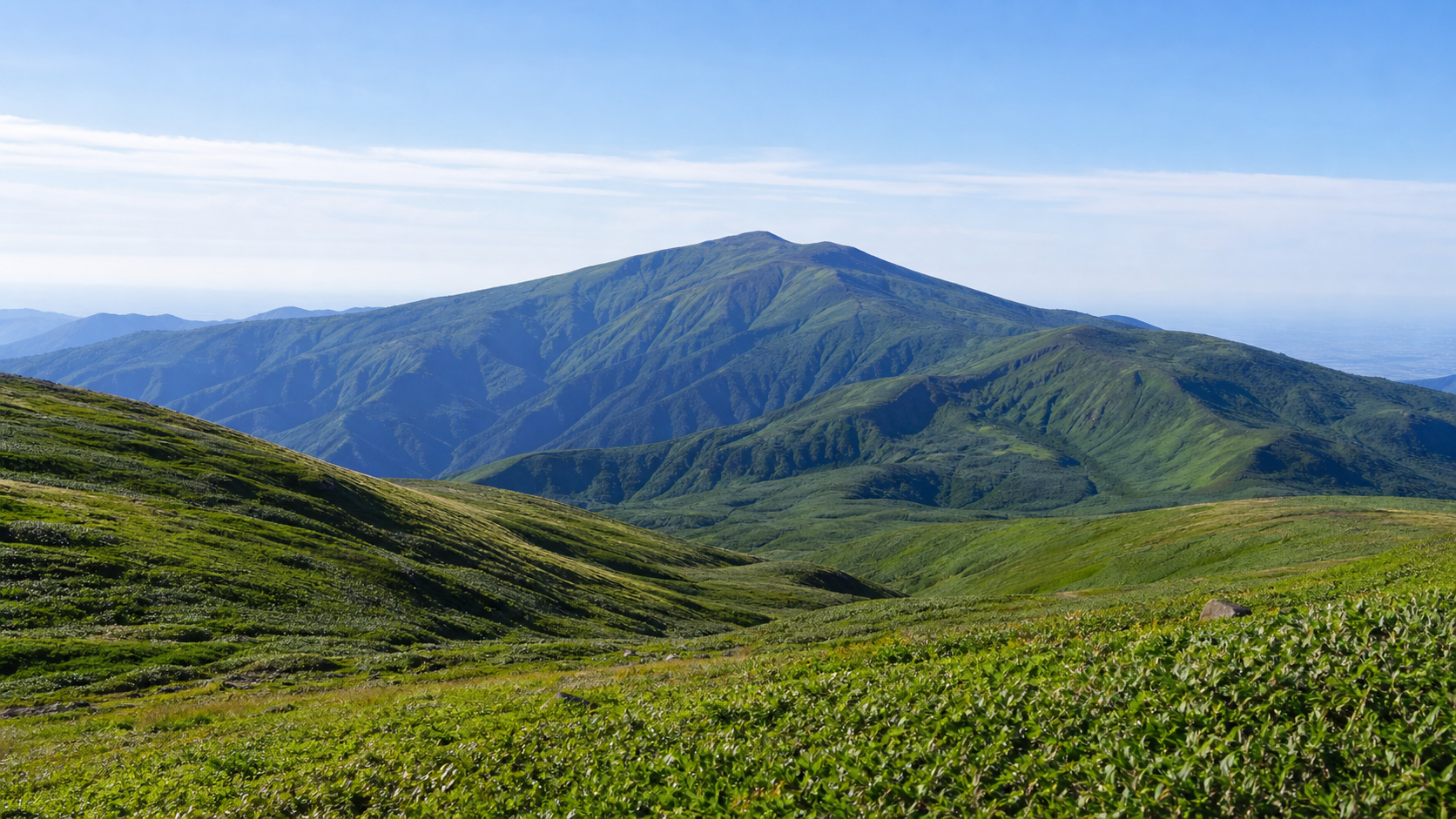 信仰の山と広い高原景観を望む月山のイメージ