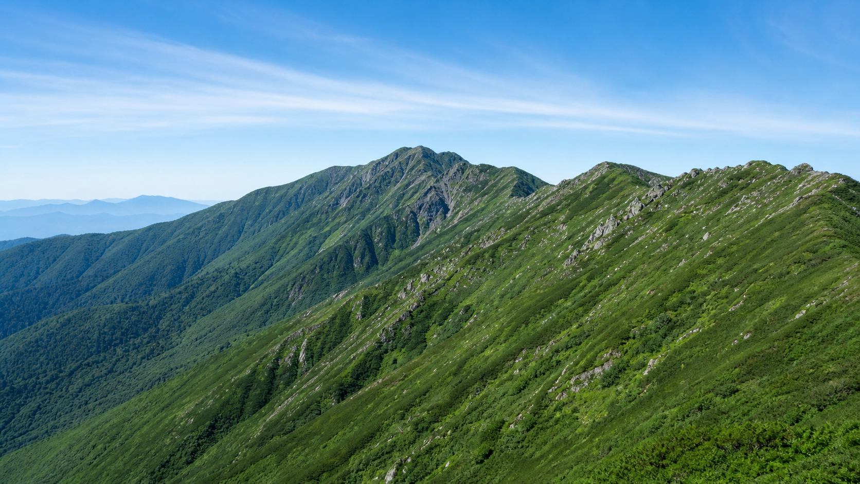 長い稜線を持つ奥深い山域を望む飯豊山のイメージ